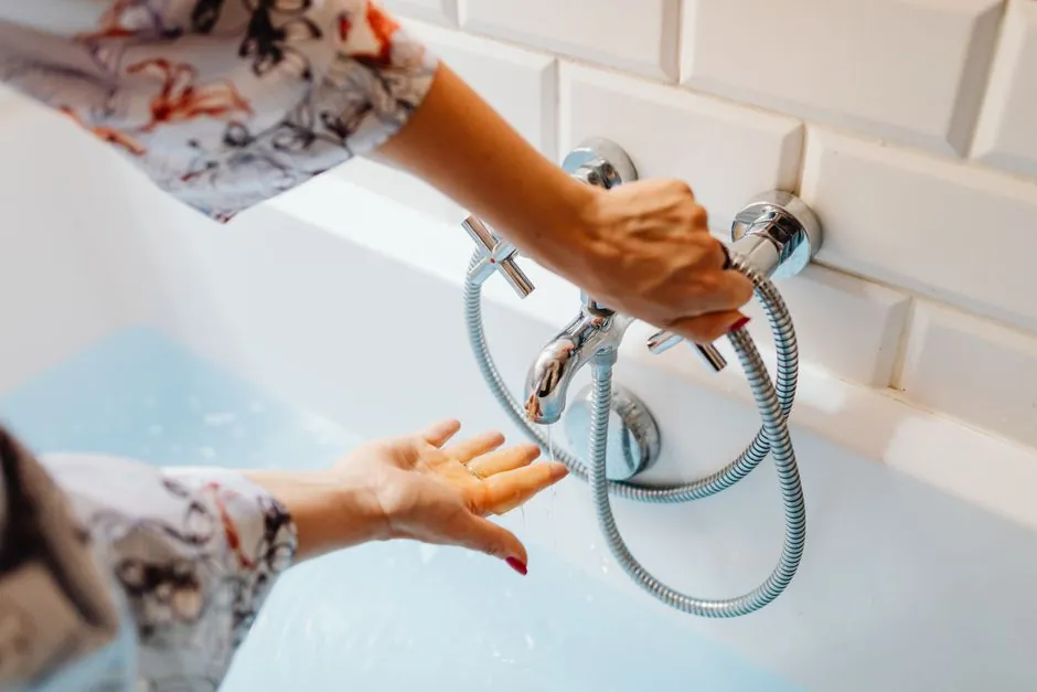 Plumber repairing a dripping bathtub faucet