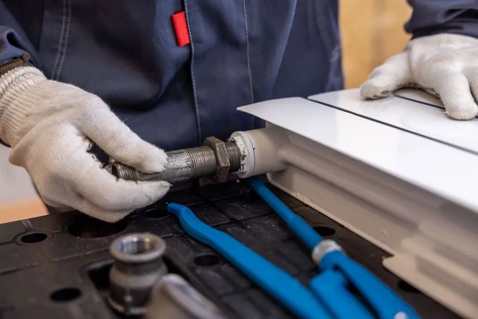 Plumber performing a seasonal plumbing maintenance checklist in a home
