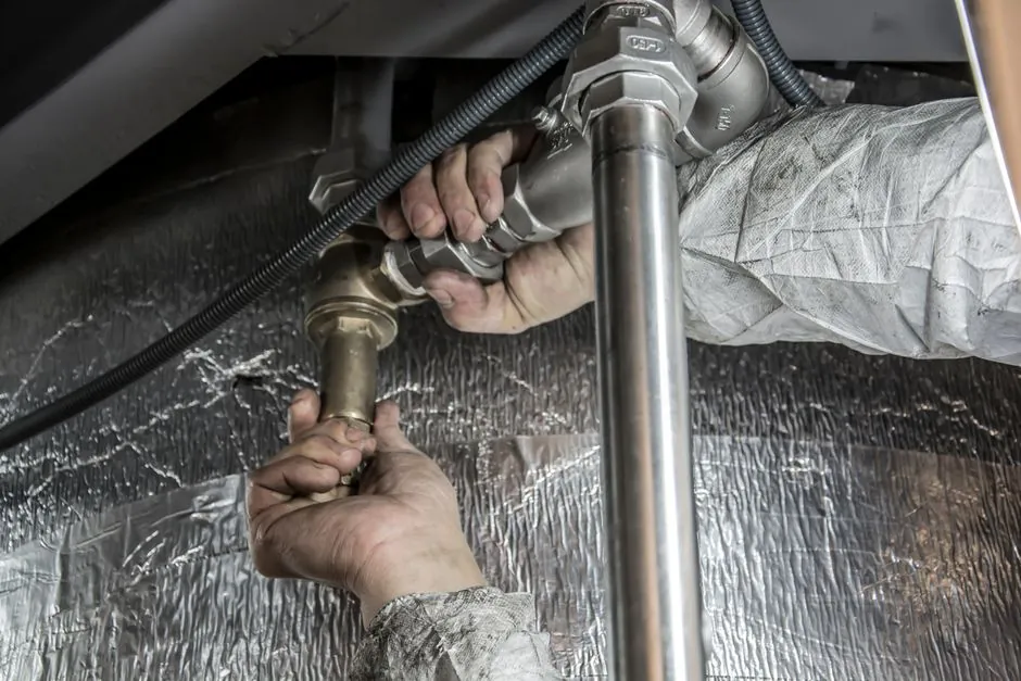 Plumber securing water supply pipes to stop water hammer